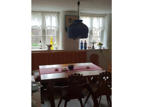 a kitchen with a table and two chairs and windows at 2 bedroom cabin in Lütgenade