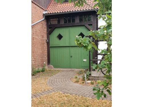 a green garage door on the side of a house at 2 bedroom cabin in Lütgenade