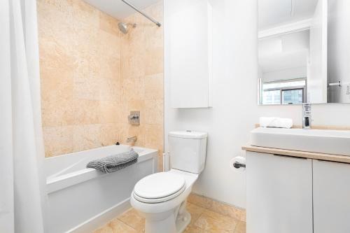 a bathroom with a toilet and a tub and a sink at Downtown Toronto 2 bedrooms with parking in Toronto