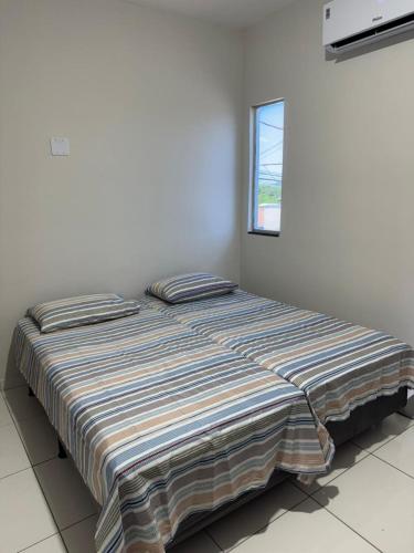 a large bed in a room with a window at Melhor custo beneficio in Governador Valadares