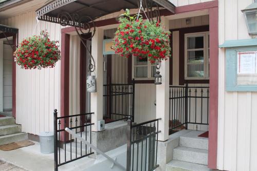 une maison avec des paniers de fleurs sur la porte d'entrée dans l'établissement Hotel Palo, à Naantali