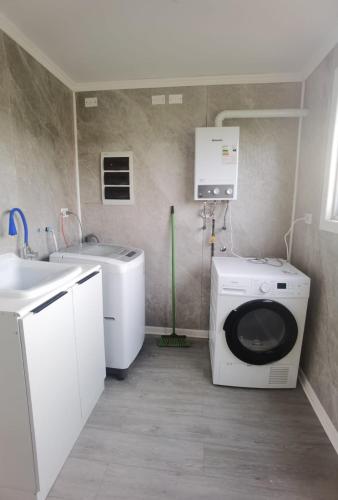 a laundry room with a washing machine and a sink at Refugio Lo Más visto in San Antonio