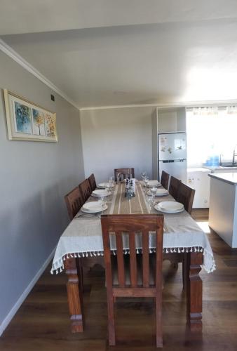 a dining room with a table and chairs and a kitchen at Refugio Lo Más visto in San Antonio