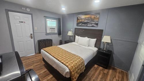a hotel room with a bed and a window at Travelers Inn in Flagstaff