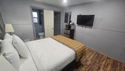 a bedroom with a bed and a flat screen tv at Travelers Inn in Flagstaff