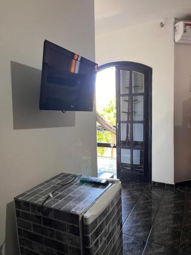 a flat screen tv hanging on a wall at Sorriso Do Sol Suites in Arraial do Cabo