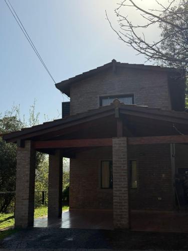 a large brick house with a front porch at La huella in Río Ceballos