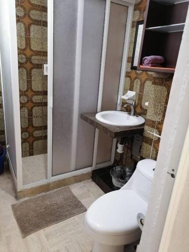 a bathroom with a toilet and a sink at FRENTE AL MAR, centrico in Acapulco