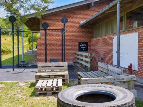 a building with a bench and a large tire at Seaside Bliss in Gilleleje-By Traum in Smidstrup