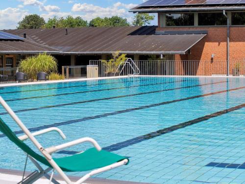 a swimming pool with a green chair in front of it at Seaside Bliss in Gilleleje-By Traum in Smidstrup