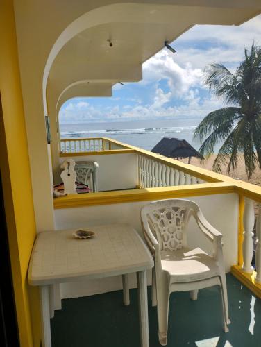 a balcony with a table and a chair and the beach at Sailfishbay Surf And Big Game Fishing Lodge in San Isidro
