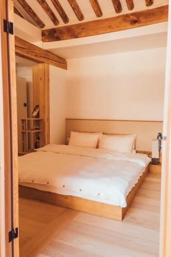 a large bed in a room with wooden floors at Gyedong Hanok 125 in Seoul
