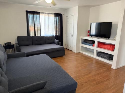a living room with a couch and a flat screen tv at Flowers Apt 5 Min Walk to Downtown - Free Parking in Las Vegas