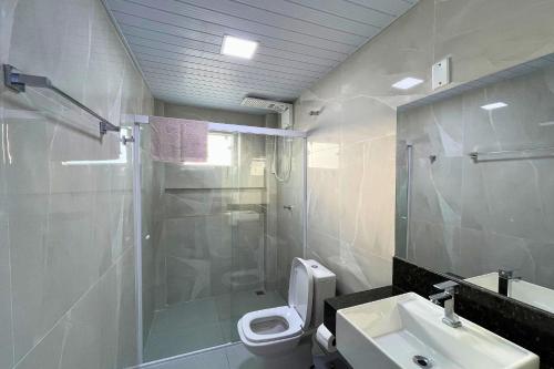 a bathroom with a shower and a toilet and a sink at Vaz Beach Residence in Penha