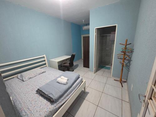 a bedroom with a bed and a desk in it at Kitnet Camilóca 1 in Campo Grande