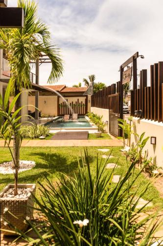 a house with a yard with a palm tree at Pousada Pedra da Pipa in Pipa