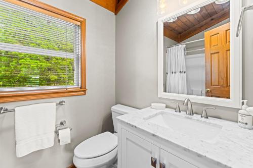 a bathroom with a toilet and a sink and a mirror at Ma Cook Lodge - Sharps Chapel in Maynardville