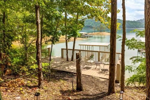 a wooden deck with a table and chairs on a lake at Ma Cook Lodge - Sharps Chapel in Maynardville