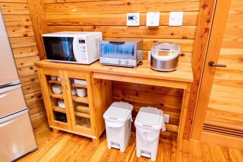 una cucina con forno a microonde ed elettrodomestici su un bancone di あさひプライム リゾートコテージ a Asahi