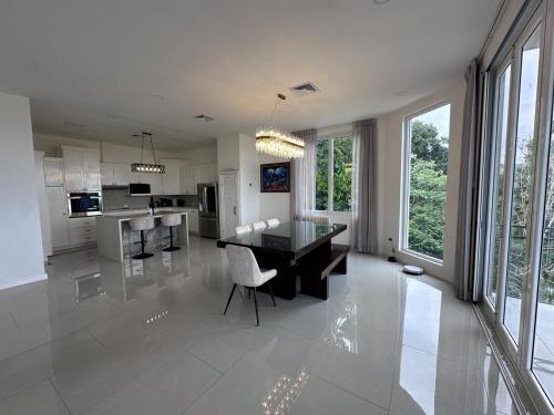 a large white kitchen with a dining table and chairs at Luxury 4BR home with Infinity Pool, Jacuzzi & firepit in Playa Hermosa