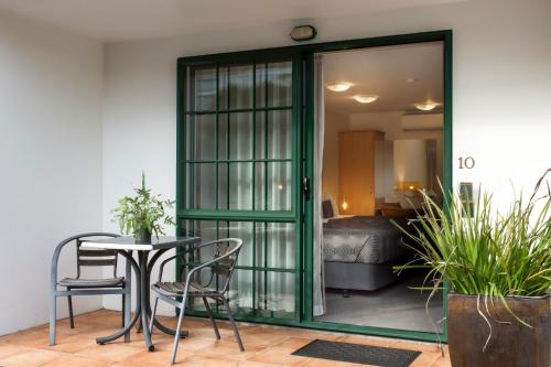 a room with a table and chairs and a bedroom at Greenlane Manor Motel in Auckland