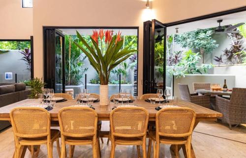 a dining room with a large wooden table and chairs at Villa Amalfi - Port Douglas in Port Douglas