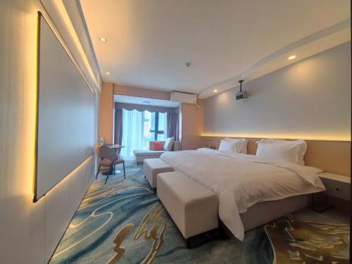 a hotel room with a large bed and a couch at 成都格兰朵酒店宽窄巷子店 in Chengdu