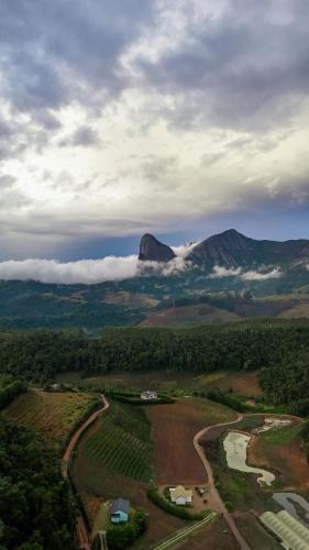 an aerial view of a mountain with a river and clouds at Rancho do Lagarto Pedra Azul in Domingos Martins