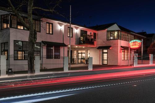 a pink building with a neon sign on a street at Greenlane Manor Motel in Auckland