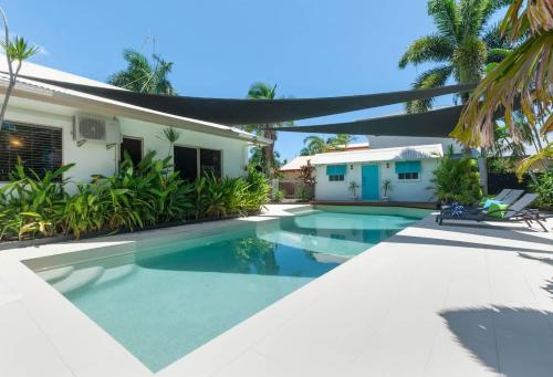 a swimming pool in front of a house at Paradise on Ruby - Port Douglas in Port Douglas