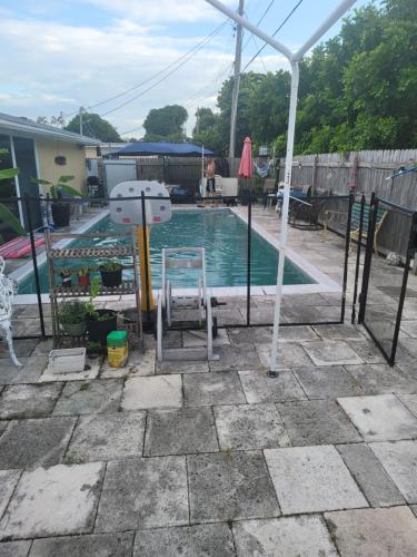 a swimming pool with a chair and an umbrella at LakeOkechobeFishingfrm22DaylyfourprsMinPartyPerRoom in Pahokee