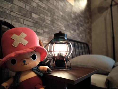 a stuffed teddy bear sitting on a table next to a lantern at Nagoya Apricot House Entire Villa in Nagoya