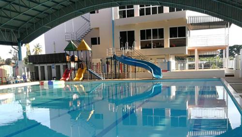 an empty swimming pool with a slide and a playground at ศุภักษรอพาร์ทเม้นและสระว่ายน้ำ Supakson apartement and pools in Sawankhalok