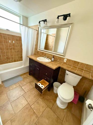 a bathroom with a toilet and a sink and a mirror at #Urban Elegance 3BR With Parking Near UC BART & Downtown in Berkeley