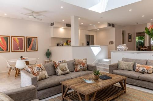 a living room with a couch and a table at Port Douglas Mirage Villa 433 - Beachfront in Port Douglas