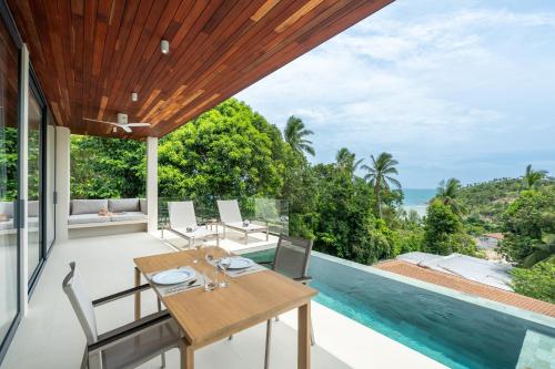 an outdoor dining room with a view of the ocean at Bay Villas Koh Phangan in Salad Beach
