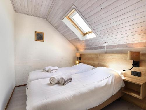 a attic bedroom with two beds with towels on them at Holiday Home in South Limburg in Vijlen