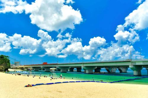 a bridge over a beach with people in the water at cuculu MAEJIMA 7F in Tomari