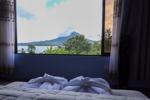 a bed with a window with a view of a mountain at Volcano & Lake View Oasis with Scenic Tub in El Castillo de La Fortuna