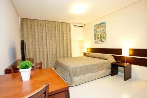 a hotel room with a bed and a desk at Flat 502 América Tower, ao lado do Salvador Shopping in Salvador