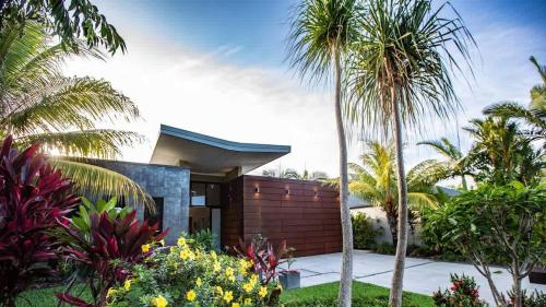 a tropical home with palm trees and plants at Tranquility by the Lake - Luxury Home Port Douglas in Port Douglas