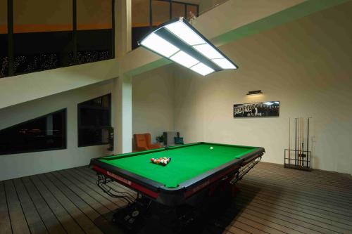 a pool table in a room with a light at 西双版纳熙源国际酒店 in Jinghong