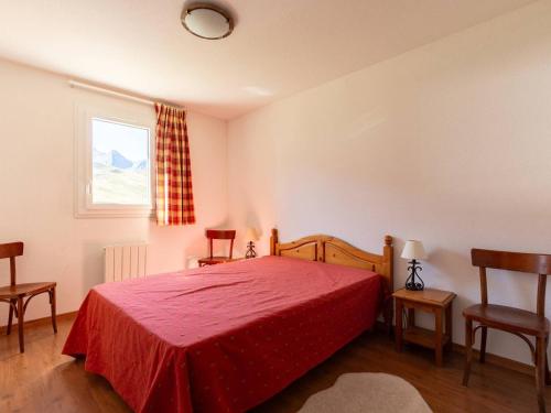 a bedroom with a red bed and two chairs at Grand Appartement à Peyragudes pour 8 personnes avec Parking - FR-1-695-84 in Germ