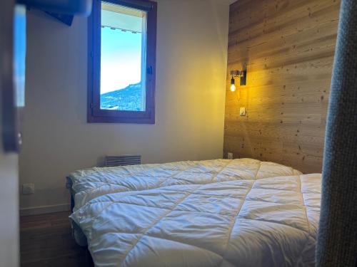 a bedroom with a bed and a window at Appartement cosy 2 pièces au pied des pistes, balcon vue sur Mont Blanc - FR-1-329-102 in Montchavin