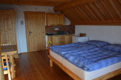 a bedroom with a bed with a blue comforter at Chalupa Ambra in Prachatice