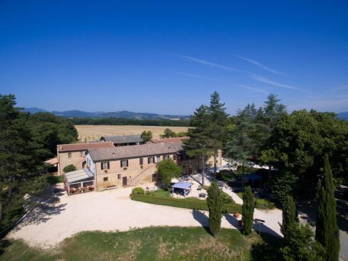an aerial view of a large brick building with trees at Casale San Galgano in Chiusdino