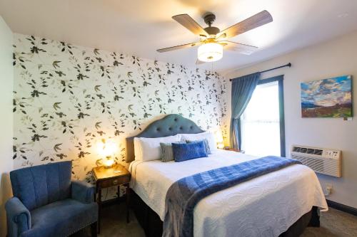 a bedroom with a bed and a blue chair at Hotel Stevenson in Stevenson