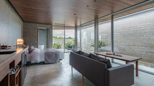 a bedroom with a bed and a table and chairs at Tanegashima Araki Bekkan in Nishinoomote