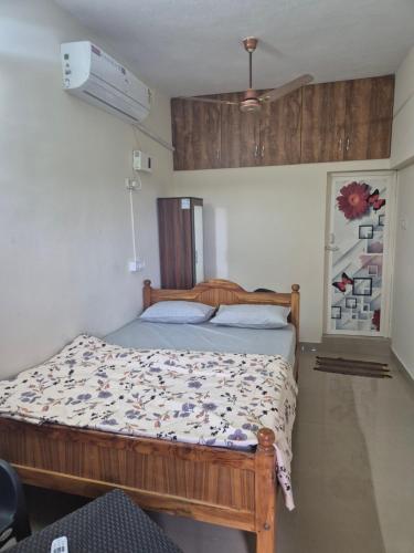 a bedroom with a wooden bed in a room at STM StayInn in Nāttarasankottai