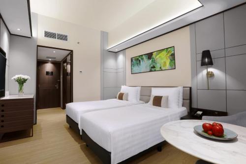 a hotel room with two beds and a table at The Alts Hotel in Palembang